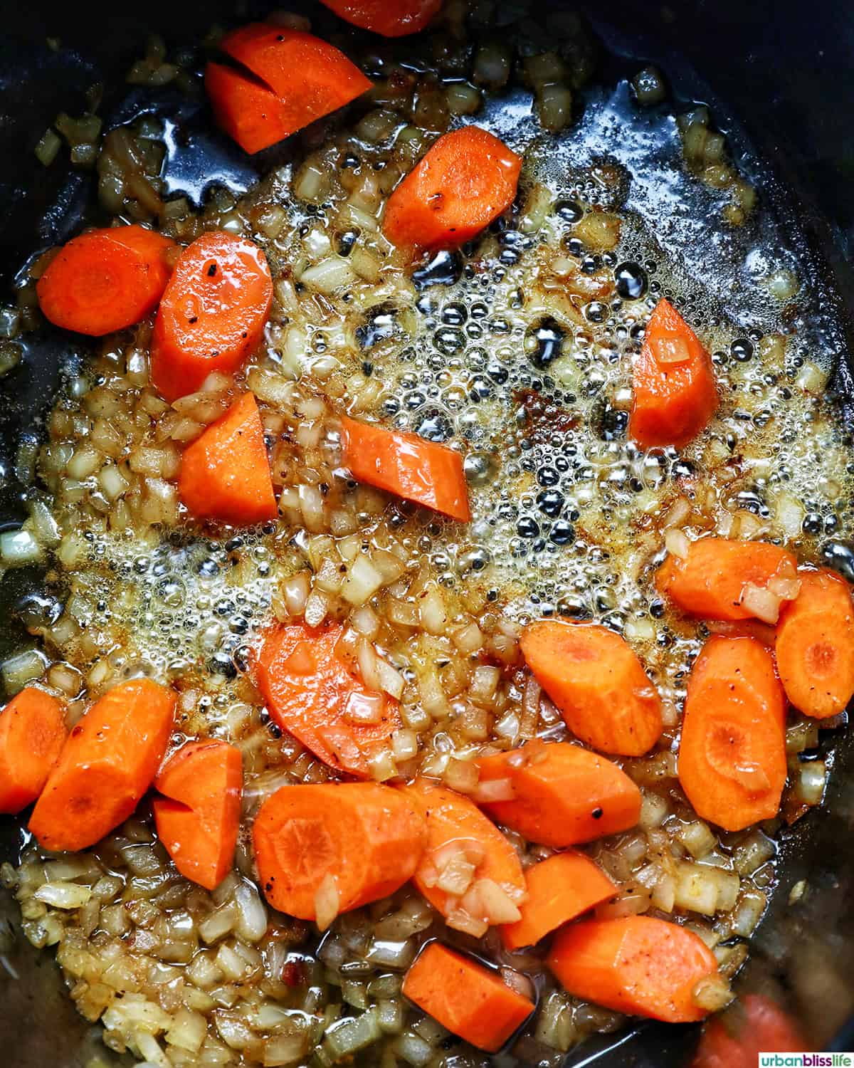 vegetables in a dutch oven cooking to make coq au vin.