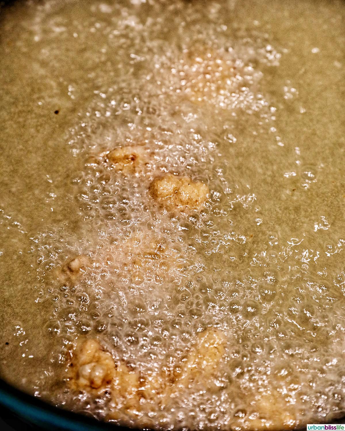 Taiwanese popcorn chicken frying in a Dutch oven filled with cooking oil.