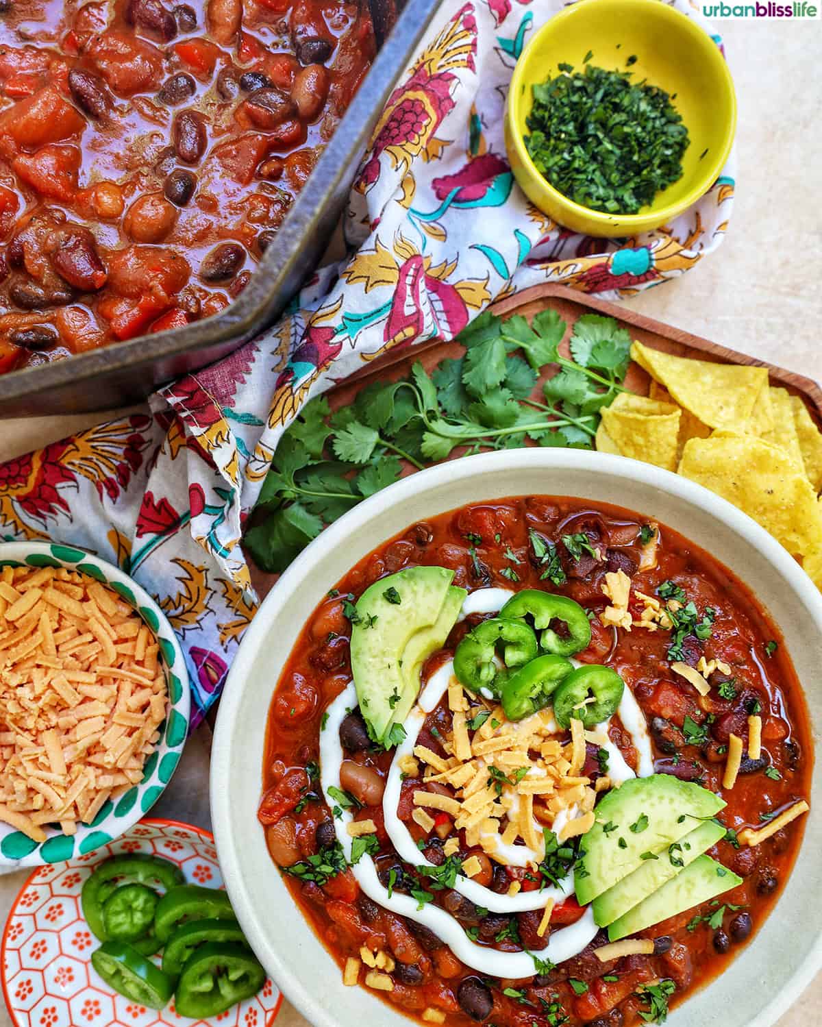 bowl of vegan three bean chili with toppings.