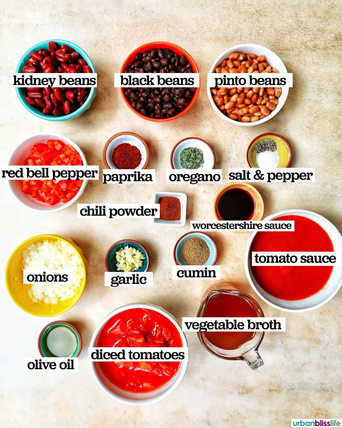 bowls of ingredients with titles to make vegan three bean chili.