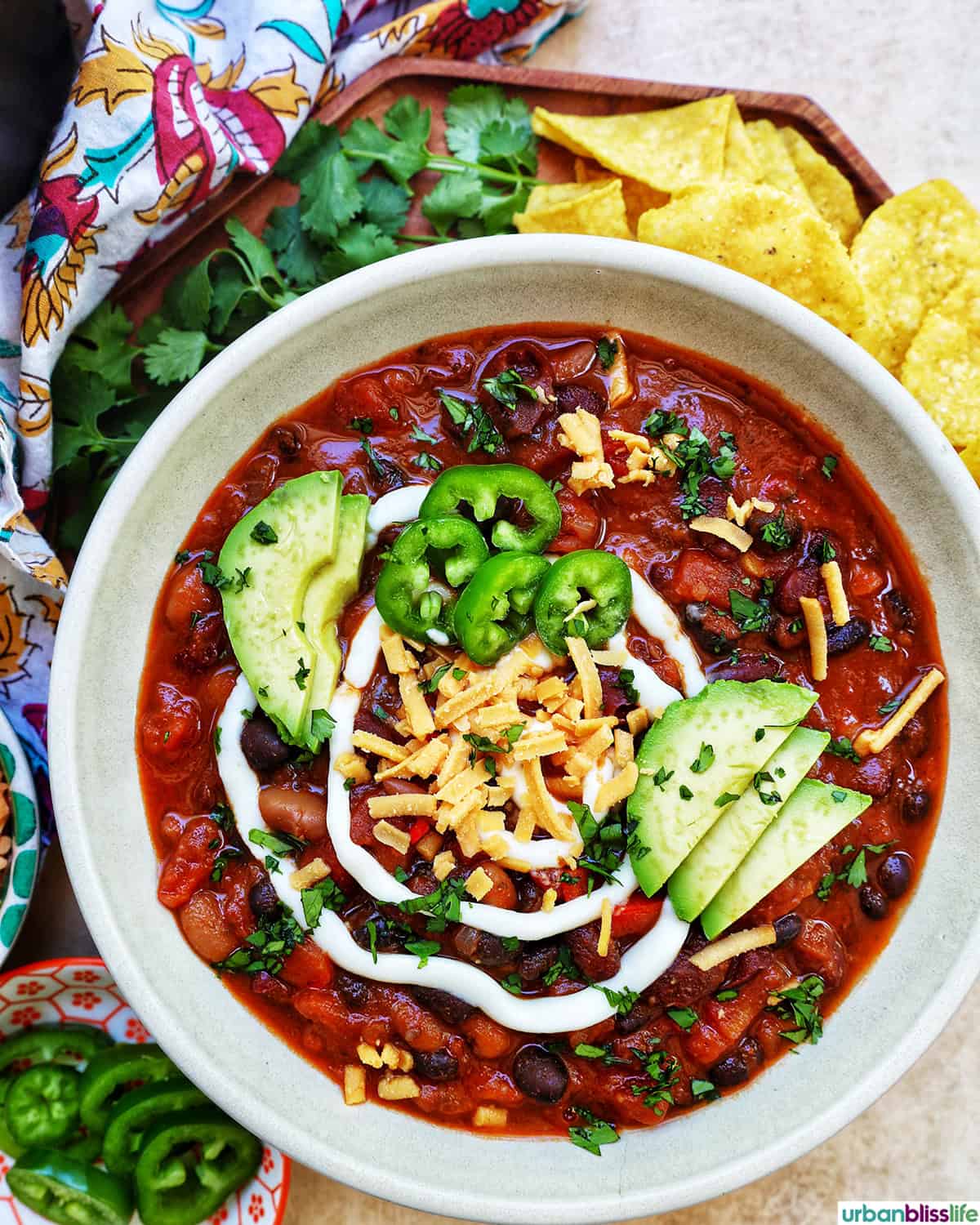 bowl of vegan three bean chili with toppings.