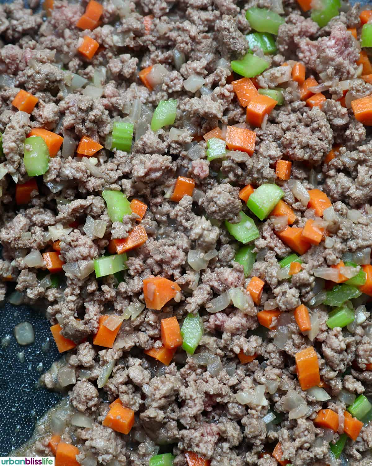 meat added to celery, carrots, onions, garlic to make baked pasta bolognese.