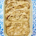baking dish with coffee cinnamon rolls against a blue and white French backdrop.