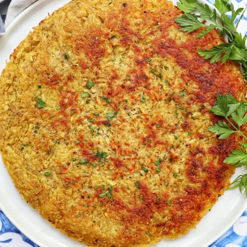 swiss rosti on a plate with parsley garnish.