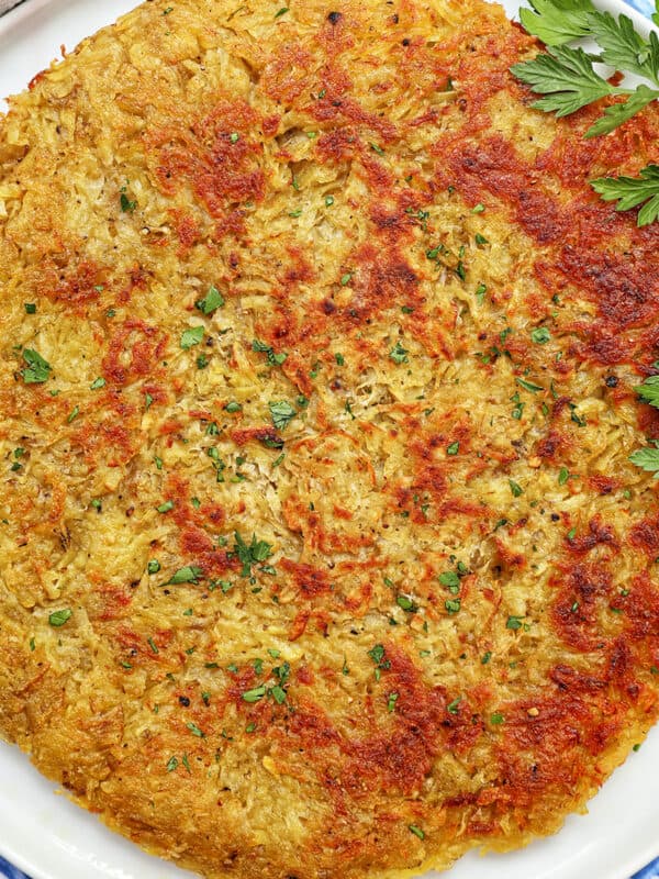 swiss rosti on a plate with parsley garnish.