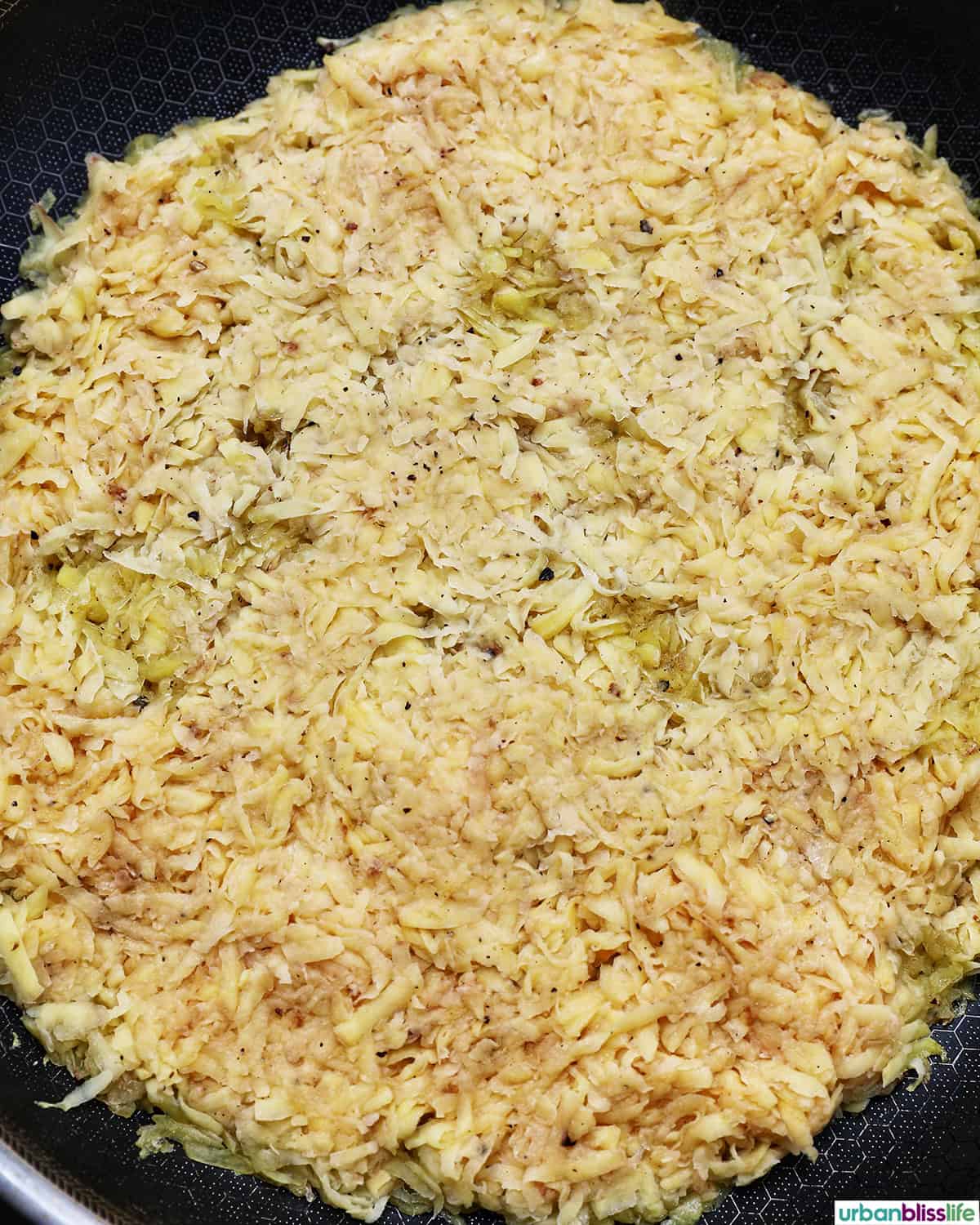 grated potatoes in a pan to make Swiss rosti.