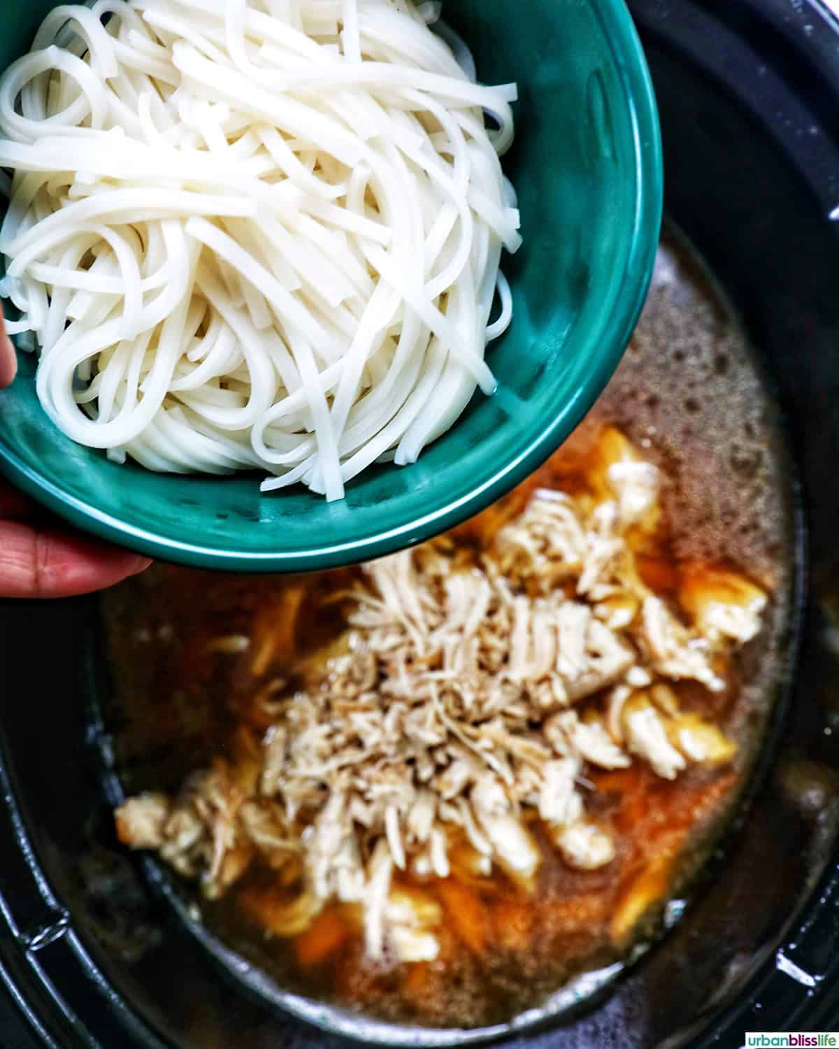 adding pho noodles to slow cooker chicken.