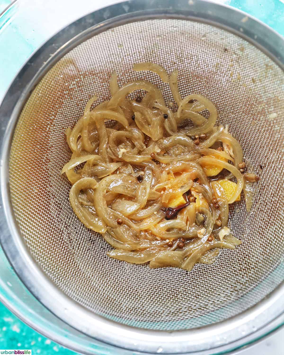 straining out solids from chicken pho soup.
