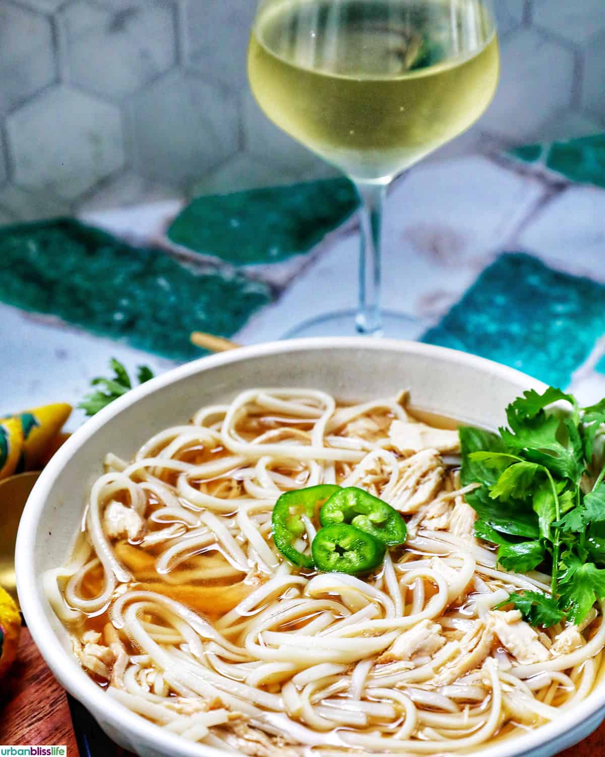 bowl of slow cooker pho soup with a glass of white wine.
