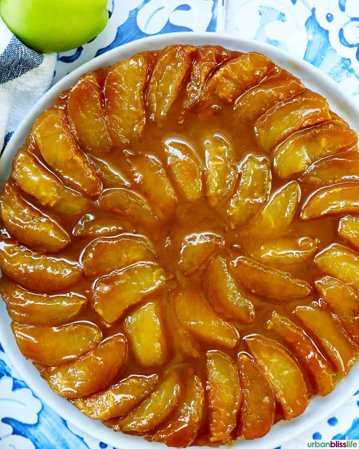 baked Pomme Tarte Tatin and a green apple on the side.