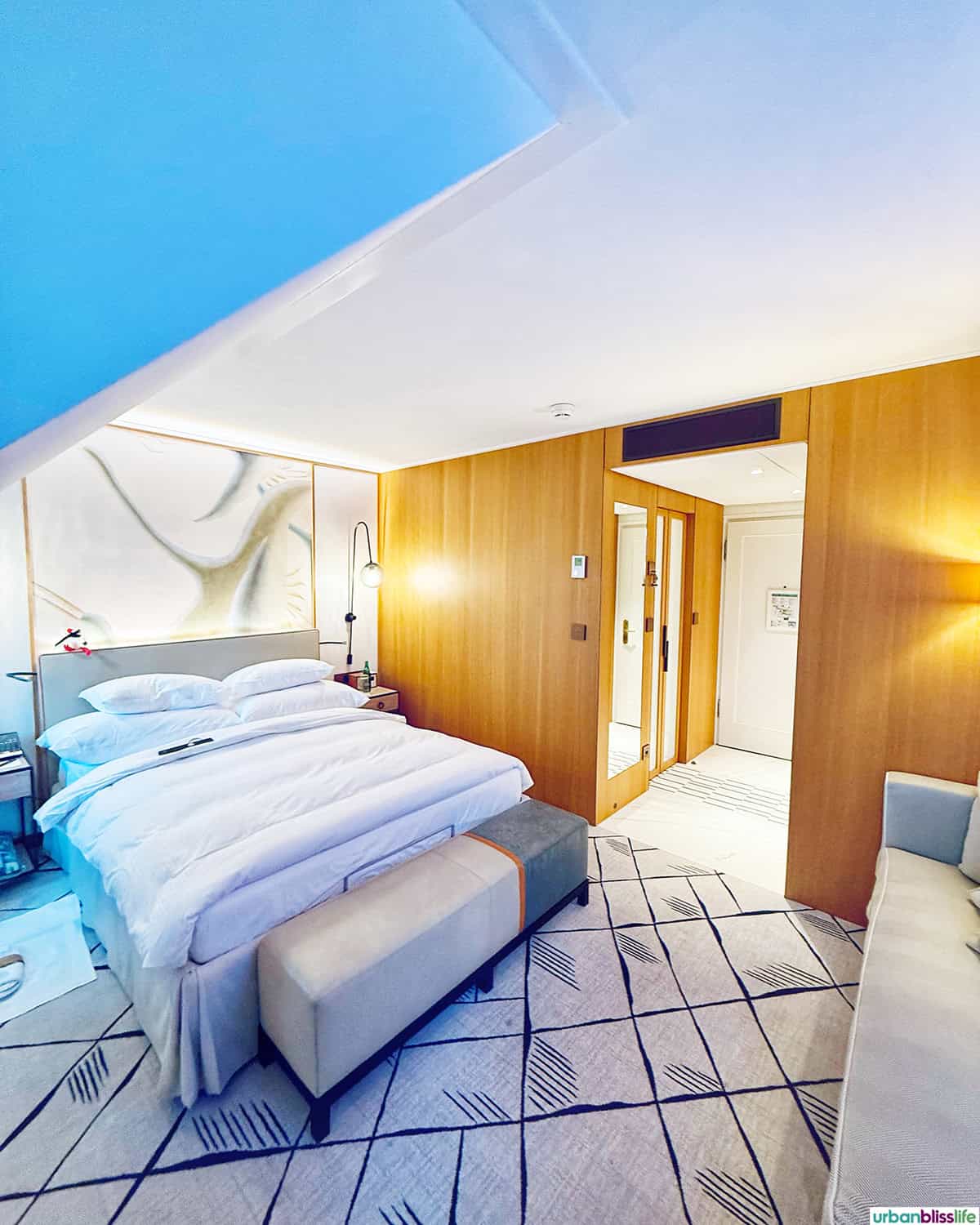 bed and hallway to bathroom in a suite at Hotel Storchen Zürich, Swiss 5-star Michelin hotel.